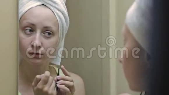 美丽的女人在镜子前挑起眉毛视频的预览图