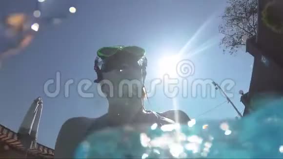 游泳池水下戴面具的快乐女孩看镜头泡泡阳光视频的预览图