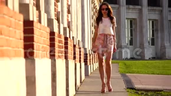 穿高跟鞋走在红砖墙附近的漂亮女孩放大我们的视频视频的预览图