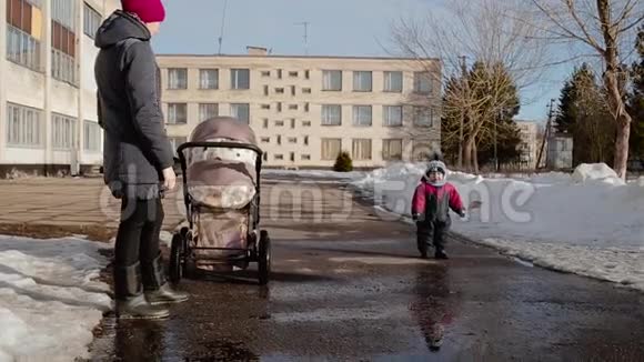 妈妈和她的孩子在冬天在街上白天视频的预览图