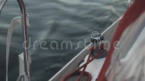 帆船板的近景白色游艇溅起浪花绳索固定在绞盘头周围视频的预览图