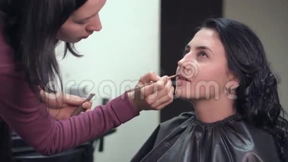 化妆师在模特嘴唇上涂口红视频的预览图