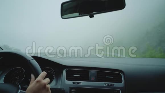 在雾蒙蒙的高速公路上开车的年轻司机视频的预览图