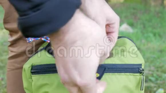 男人手紧紧抓住一个绿色背包单词超级爸爸的尼龙搭扣把补丁藏在拉链口袋里视频的预览图