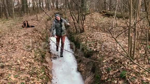 人在森林里冰冻的小溪上奔跑和滑行视频的预览图
