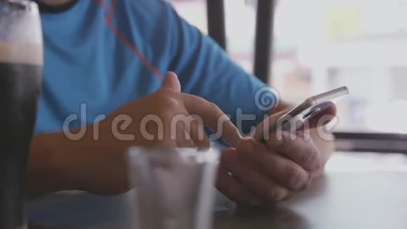 在一家街边的咖啡馆里男人用手机发短信3840x2160视频的预览图