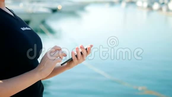 女性手持智能手机背景模糊配有游艇视频的预览图