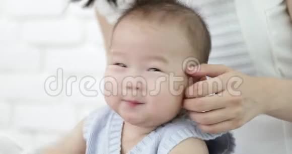 快乐的亚洲家庭宝宝和父母一起在家玩笑脸视频的预览图