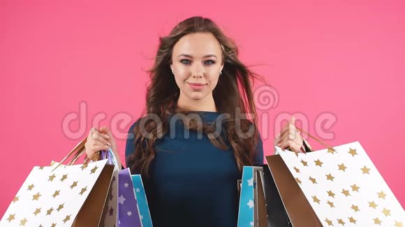 幸福微笑的女人拿着购物袋的肖像女模特隔离工作室背景视频的预览图
