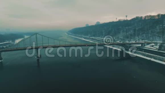 城市上的桥雾蒙蒙的冬日里的人行天桥空中无人驾驶飞机的镜头视频的预览图