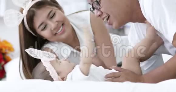 快乐的亚洲家庭宝宝和父母一起在家玩笑脸视频的预览图