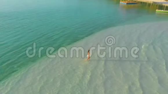 菲律宾热带岛屿白沙上独身女子的空中景色视频的预览图