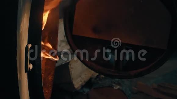炉子里烧木头人手关上炉子的门把它锁上视频的预览图
