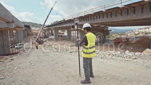 在大型建筑工地使用GPS测量装置的建筑工程师视频的预览图