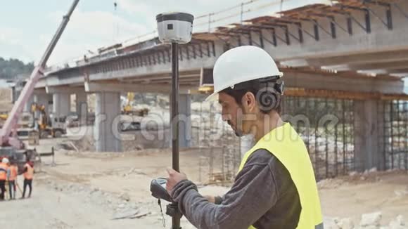 在大型建筑工地使用GPS测量装置的建筑工程师视频的预览图