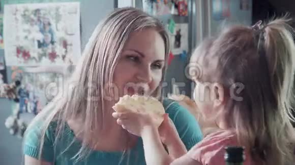 妈妈和女孩吃奶酪然后拥抱和亲吻视频的预览图