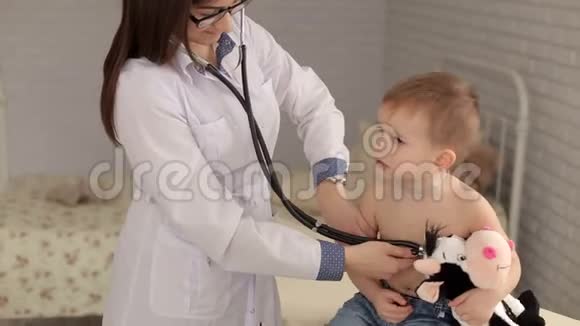 女儿科医生用听诊器检查可爱的小男孩视频的预览图