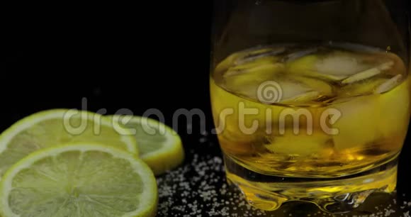 威士忌加冰在黑色背景下从瓶子里倒入威士忌朗姆酒视频的预览图