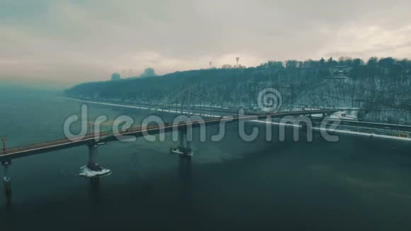 城市上的桥雾蒙蒙的冬日里的人行天桥空中无人驾驶飞机的镜头视频的预览图