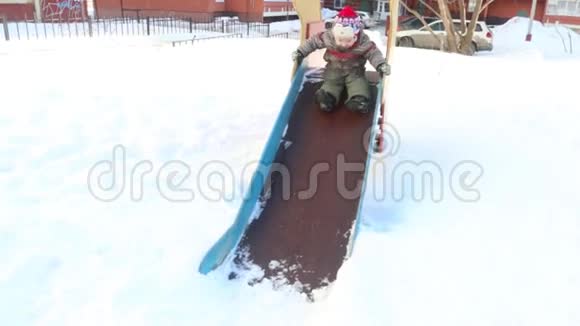 快乐的小男孩滑下来小女孩在冬天阳光明媚的日子视频的预览图