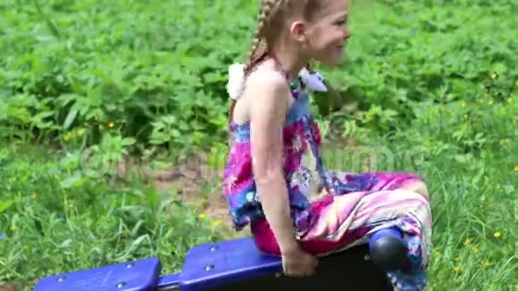 小女孩在绿色公园的户外运动中做腹肌练习视频的预览图