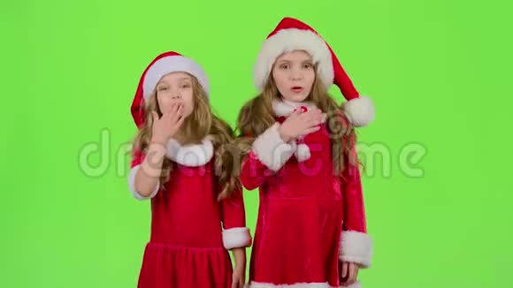 戴着红色圣诞帽的孩子们送空气亲吻绿色屏幕视频的预览图