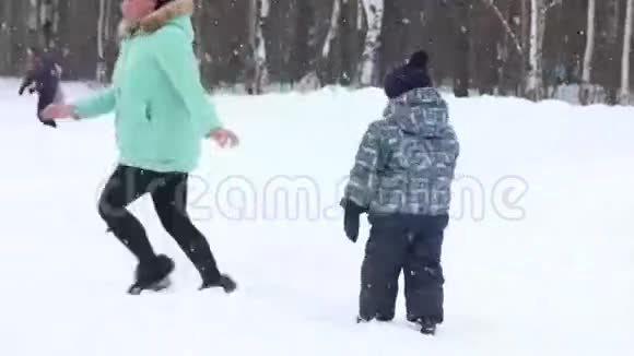 公园降雪时一个女人和三个孩子吐雪视频的预览图