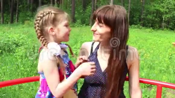 美丽的女孩亲吻她的母亲绿色的夏天公园视频的预览图