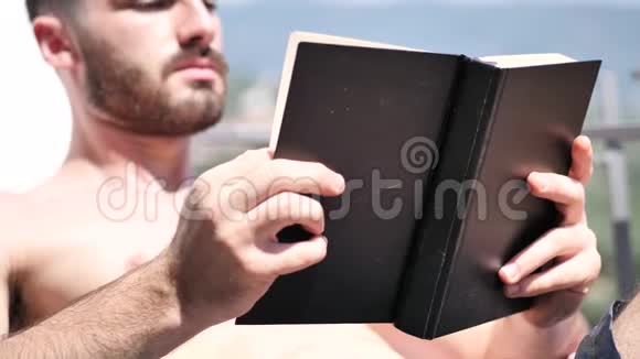 在躺椅上看书的年轻人视频的预览图