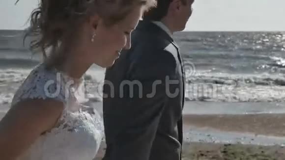 一对在海滩上散步的情侣手牵着手肖像镜头移动视频的预览图
