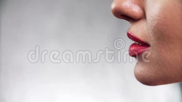 红色口红女人用口红涂满嘴唇的特写视频的预览图