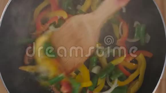 厨师把蔬菜混合在煎锅里视频的预览图