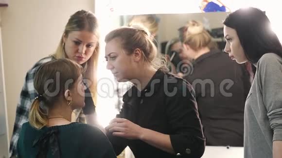 化妆师学生和模特学习过程年轻的金发女郎化妆师把眉毛画成漂亮的视频的预览图