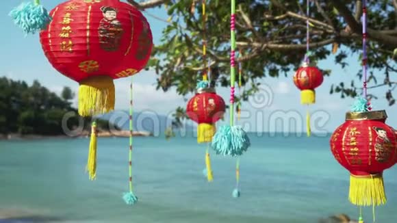 东方装饰灯笼红色的中国灯挂在树上海边的背景3840x2160视频的预览图