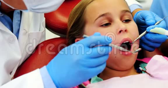牙科医生和护士用工具检查一名年轻病人视频的预览图