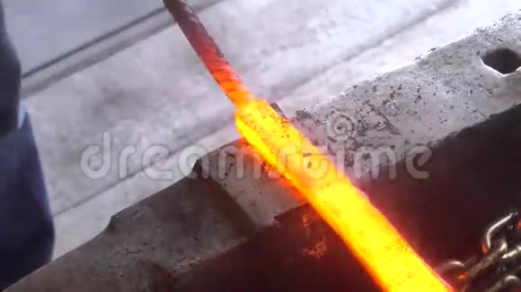 铁匠用铁锤在铁砧上锻造红色的热铁水接近4k视频的预览图