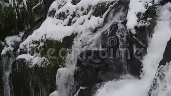 瀑布从冰冷的岩石上倾泻下来视频的预览图