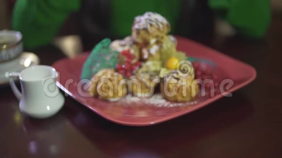 提供美味可口的奶油泡芙奶油奶油摩丝糕点布丁蛋糕甜点和方形红色盘子上的浆果视频的预览图