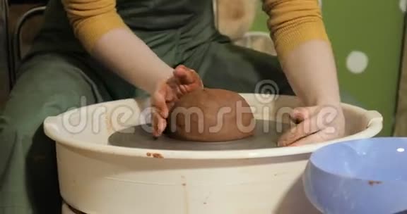 成年女陶工师傅在陶工车轮上准备粘土视频的预览图