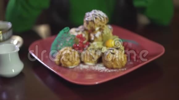 近距离观看美味可口的奶油泡芙慕斯蛋糕布丁蛋糕甜点与浆果在方形红色盘子视频的预览图