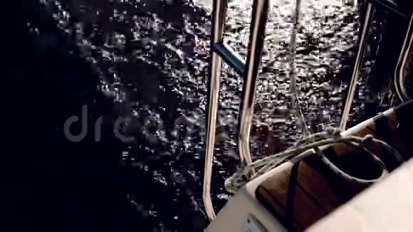 帆船的后部以全速穿过海浪在阳光明媚的日子里游艇在风中航行视频的预览图