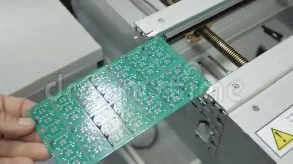 工人在生产线上贴上带有芯片的绿色板材视频的预览图