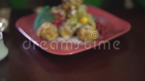 近距离观看美味可口的奶油泡芙慕斯蛋糕布丁蛋糕甜点与浆果在方形红色盘子视频的预览图
