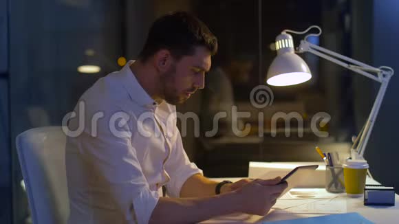有平板电脑的商人在夜间办公视频的预览图
