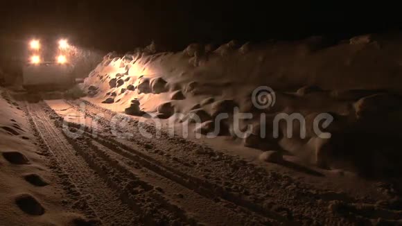 暴风雪期间雪犁在夜间沿着道路移动视频的预览图