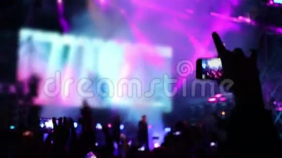 在激光表演和照明的音乐会上手持手机专注于手视频的预览图