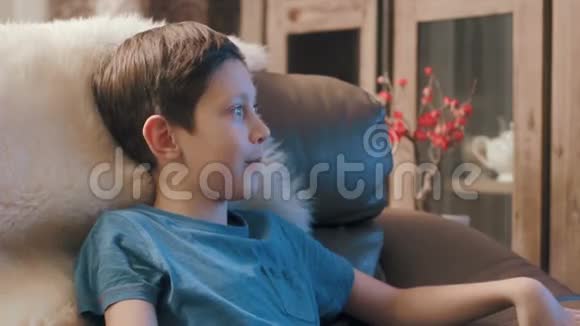 小男孩在家看电视面带微笑视频的预览图