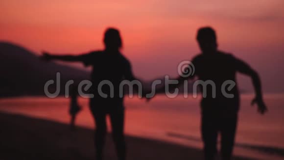 浪漫的一对夫妇在令人惊叹的日落时分牵着手在海滩上奔跑旅行中享受日落的快乐年轻夫妇视频的预览图