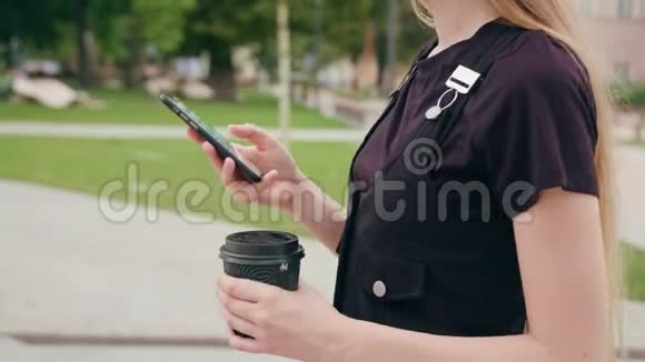 年轻的红头发女士在城里散步和使用电话视频的预览图