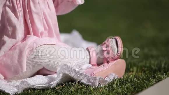 在公园的绿草上美丽的女婴座位的特写视频的预览图